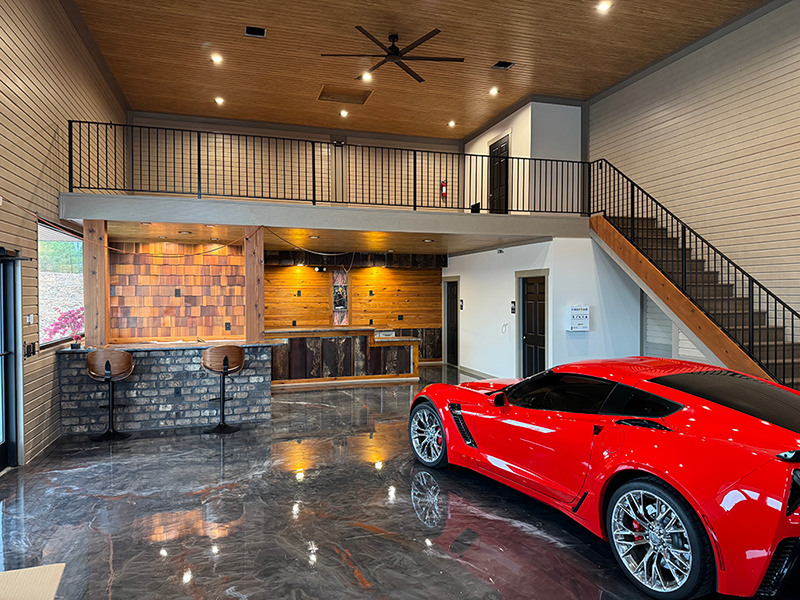 interior of condo storage unit at The Garages at LKN showing sports car on lower floor and loft with staircase